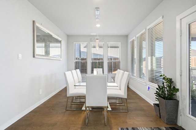 dining space with baseboards and wood finished floors