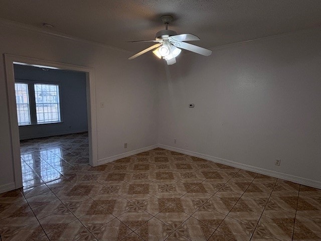 empty room featuring crown molding, baseboards, and ceiling fan