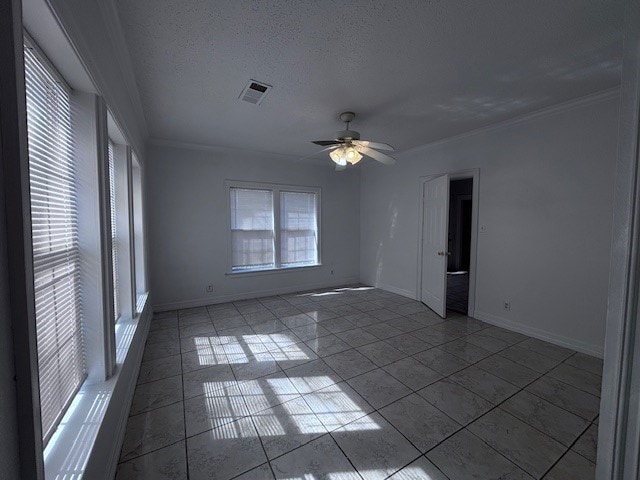 tiled spare room featuring a ceiling fan, baseboards, visible vents, and a textured ceiling