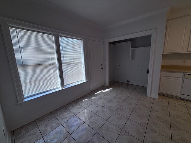 unfurnished dining area featuring light tile patterned floors and ornamental molding