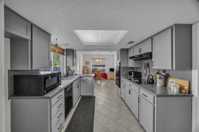 kitchen featuring decorative backsplash, gray cabinets, under cabinet range hood, and black appliances