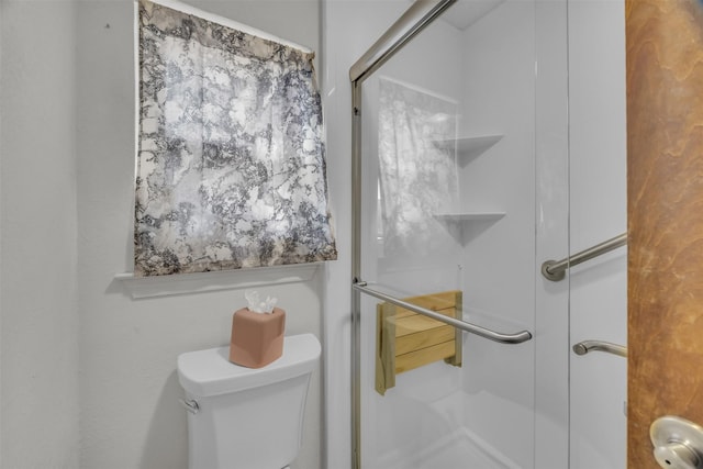 bathroom featuring a stall shower and toilet