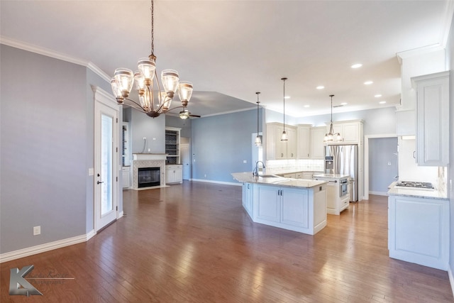 kitchen with a fireplace with flush hearth, stainless steel appliances, a sink, open floor plan, and backsplash