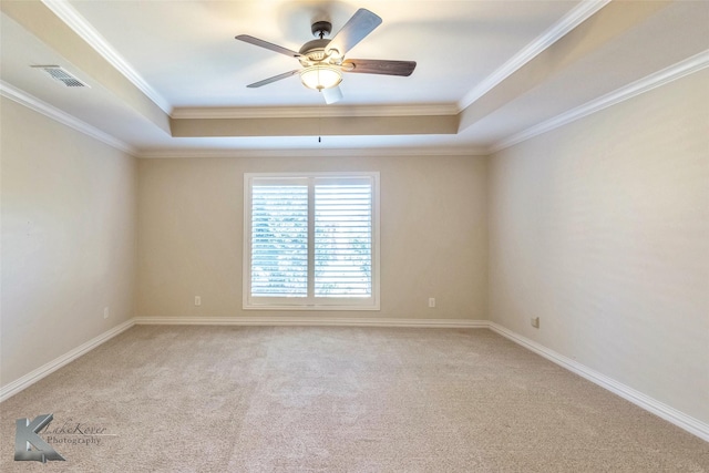 unfurnished room with light colored carpet, a tray ceiling, a ceiling fan, and visible vents