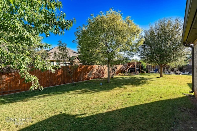 view of yard featuring fence and a playground