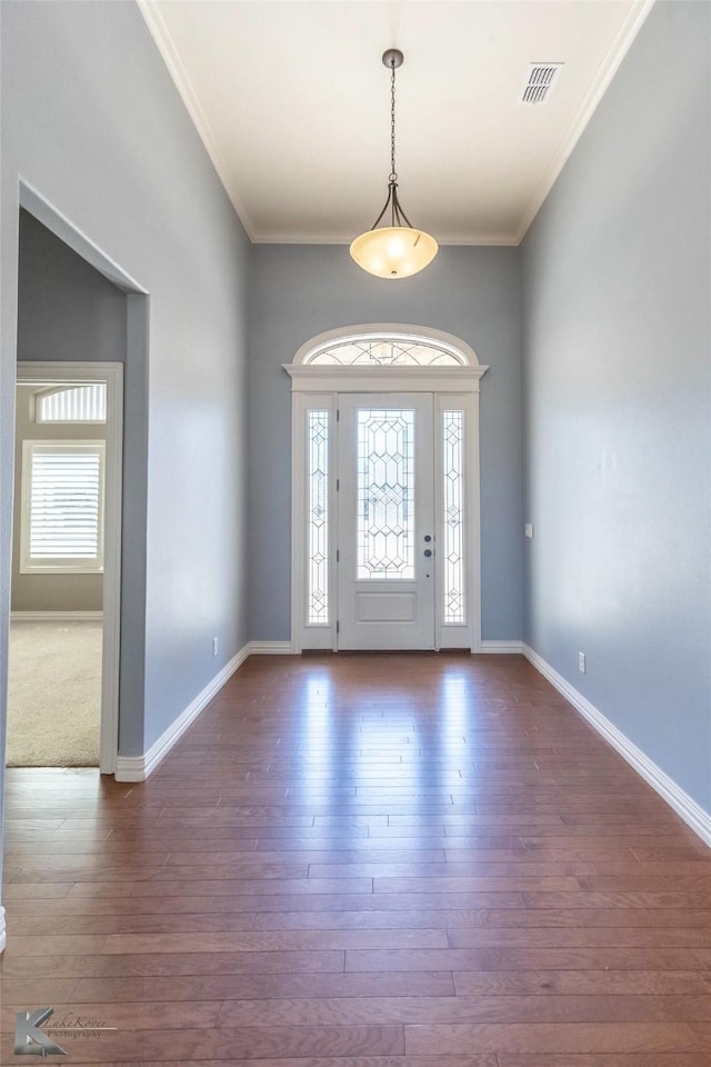 entrance foyer featuring ornamental molding and wood finished floors