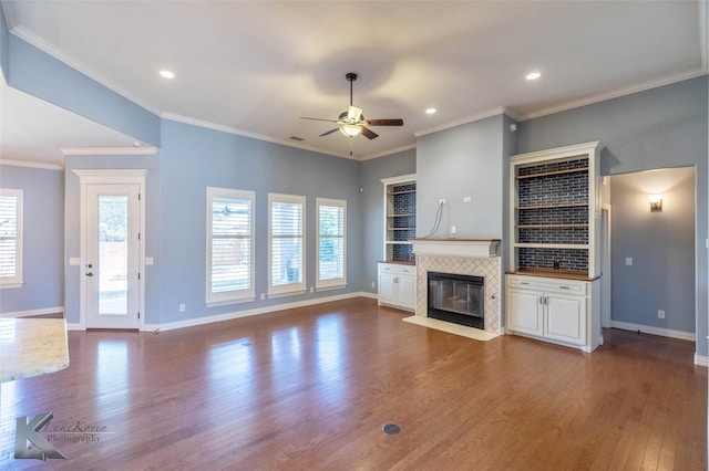 unfurnished living room featuring ceiling fan, baseboards, recessed lighting, a tile fireplace, and wood finished floors