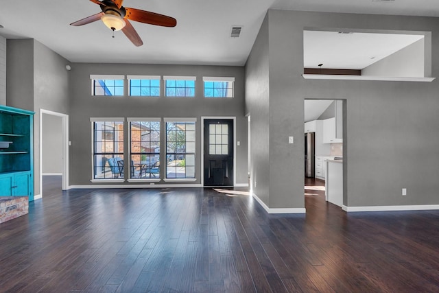 unfurnished living room with baseboards, visible vents, ceiling fan, and dark wood-style flooring