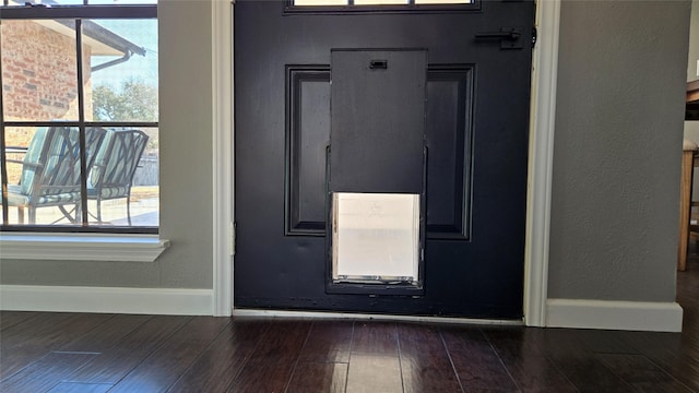 foyer featuring a textured wall, dark wood finished floors, and baseboards