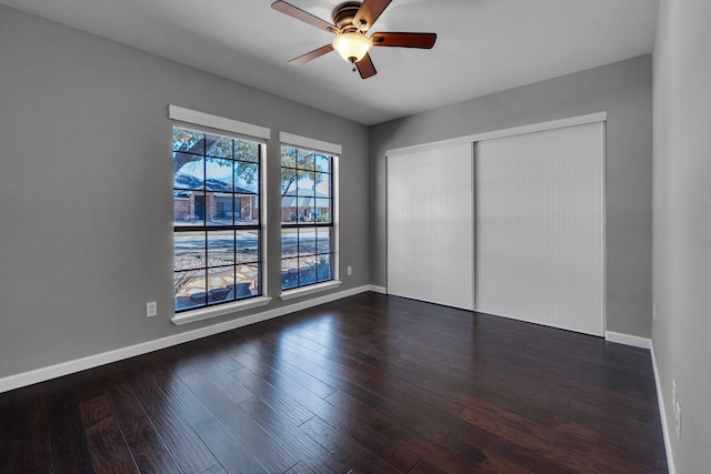 unfurnished bedroom with a closet, wood finished floors, and baseboards