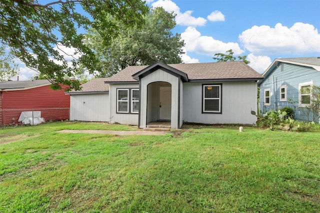 view of front of property with a shingled roof and a front yard