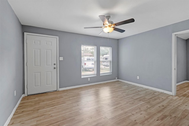 spare room featuring light wood-style floors, ceiling fan, and baseboards