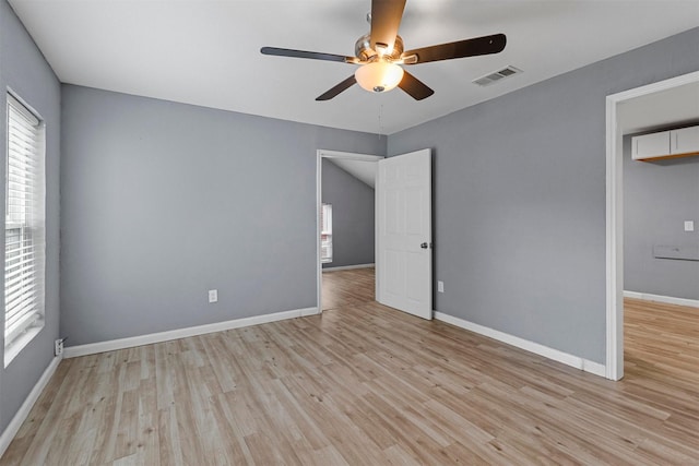 spare room featuring visible vents, ceiling fan, light wood-style flooring, and baseboards