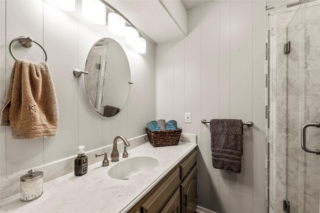 bathroom featuring a shower stall and vanity