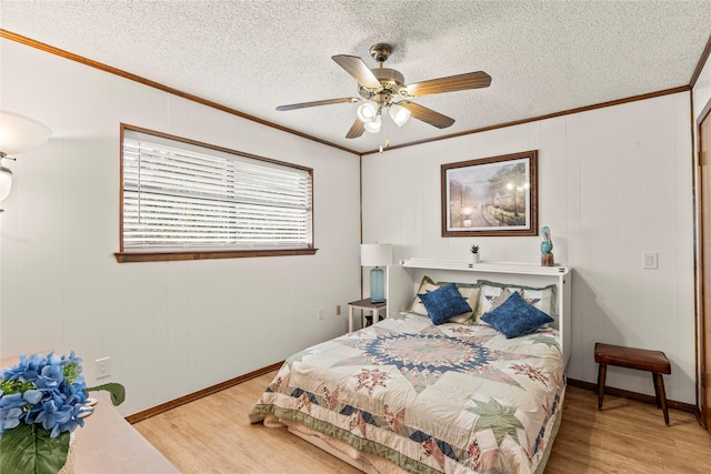 bedroom with light wood-style flooring, a textured ceiling, ceiling fan, and crown molding