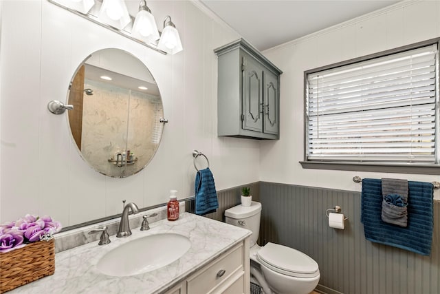 full bathroom featuring wainscoting, toilet, ornamental molding, walk in shower, and vanity