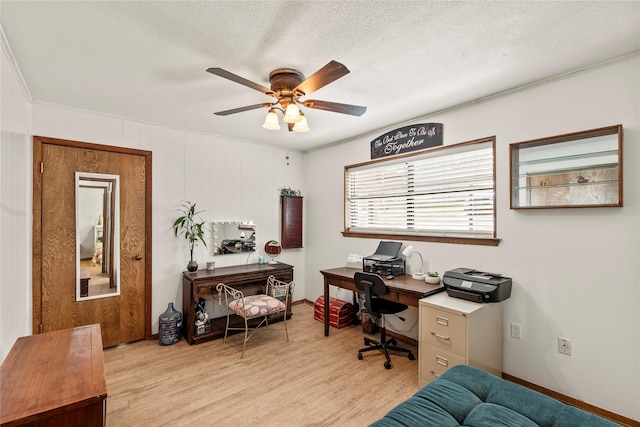 office area featuring a ceiling fan, baseboards, light wood-style flooring, and a textured ceiling