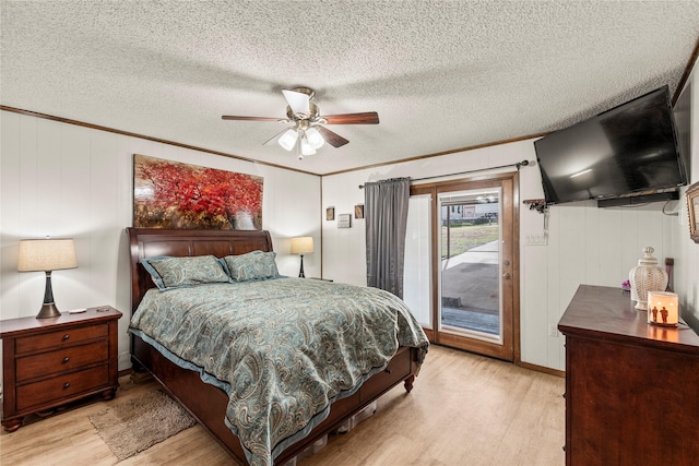 bedroom featuring ornamental molding, light wood-style floors, a textured ceiling, and access to exterior