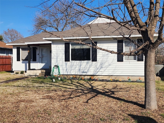 view of front of home featuring entry steps, fence, and a front yard