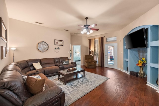 living area featuring dark wood-style floors, visible vents, and ceiling fan