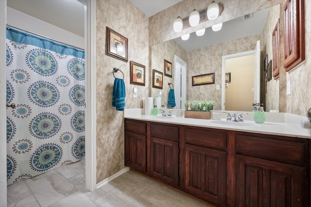 full bathroom with curtained shower, wallpapered walls, a sink, and double vanity