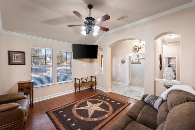 living area featuring wood-type flooring, visible vents, arched walkways, and ornamental molding