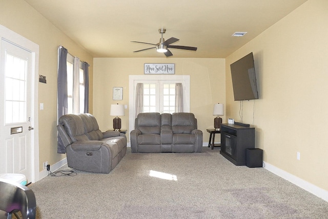 carpeted living room featuring a ceiling fan, french doors, visible vents, and baseboards