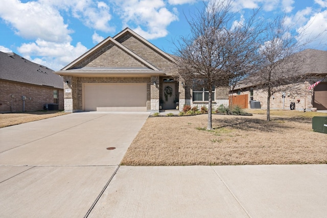 view of front of property with a garage, brick siding, driveway, and central AC unit