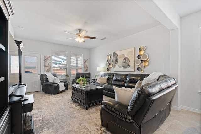 living area featuring ceiling fan, visible vents, and baseboards