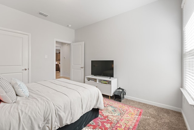 bedroom featuring baseboards, visible vents, and light colored carpet