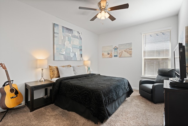 carpeted bedroom with ceiling fan and baseboards