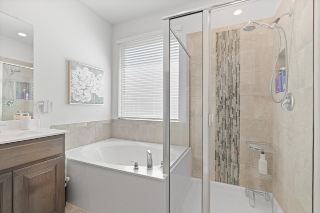 full bathroom featuring a bath, a shower stall, and vanity