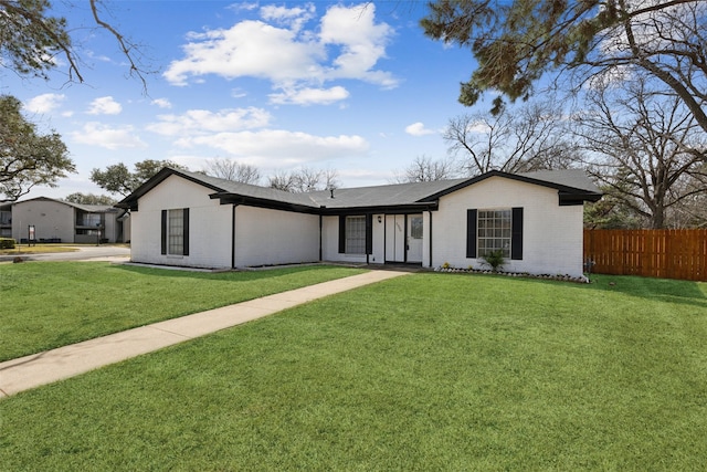 view of front of property with fence, a front lawn, and brick siding