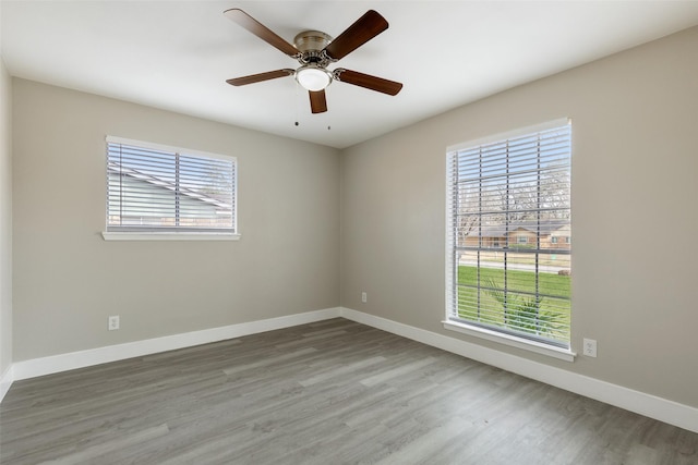 unfurnished room with a ceiling fan, baseboards, and wood finished floors