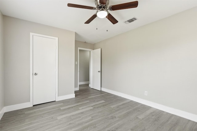 unfurnished bedroom featuring light wood finished floors, baseboards, visible vents, and a ceiling fan