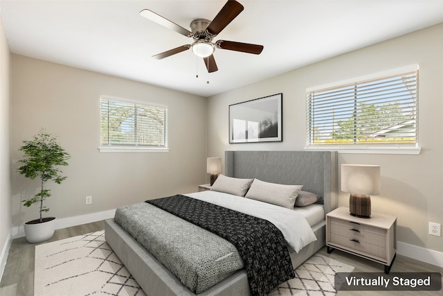 bedroom featuring light wood-style floors, baseboards, and a ceiling fan