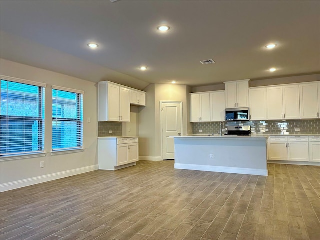 kitchen featuring stainless steel appliances, light wood-style flooring, light countertops, and visible vents