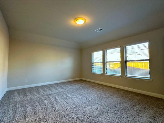 carpeted empty room with visible vents and baseboards