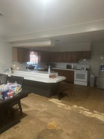 kitchen featuring white range with electric stovetop, light countertops, and a peninsula