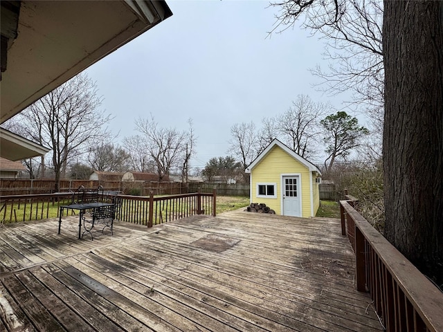 wooden deck with an outbuilding, a fenced backyard, and a lawn