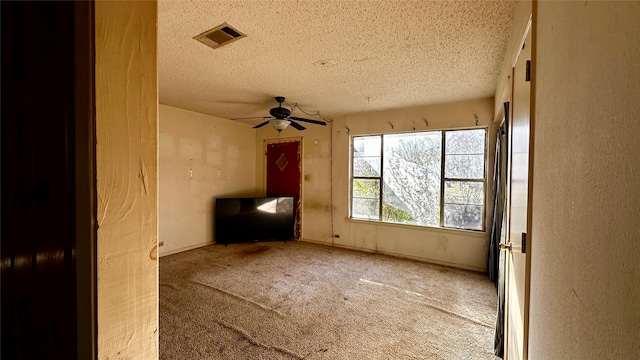 carpeted spare room with a ceiling fan, baseboards, visible vents, and a textured ceiling