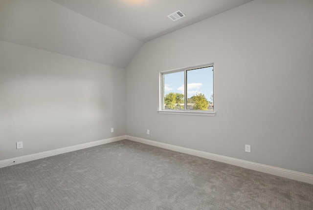 interior space with visible vents, vaulted ceiling, and baseboards