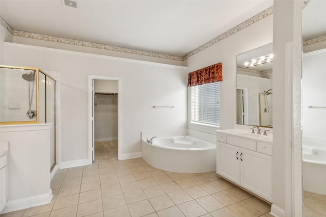 full bath featuring a stall shower, tile patterned floors, a garden tub, and vanity