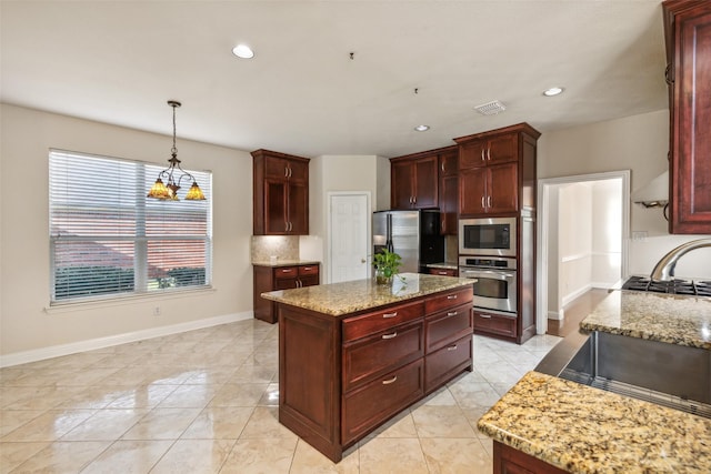 kitchen featuring light stone counters, visible vents, baseboards, appliances with stainless steel finishes, and reddish brown cabinets