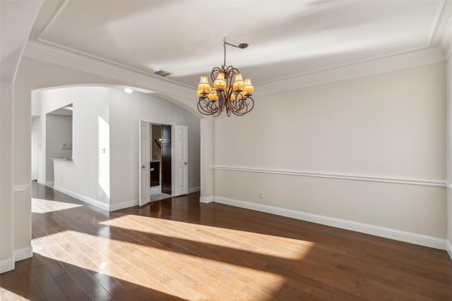 empty room with arched walkways, ornamental molding, hardwood / wood-style flooring, and visible vents