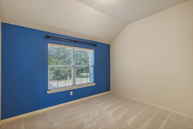 spare room with lofted ceiling, carpet floors, and baseboards