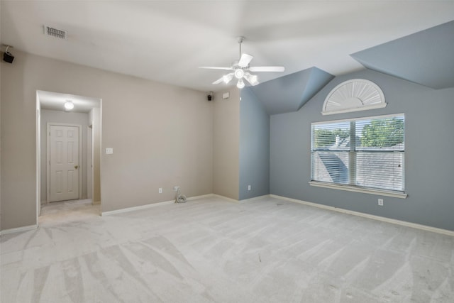 carpeted empty room with a ceiling fan, visible vents, vaulted ceiling, and baseboards