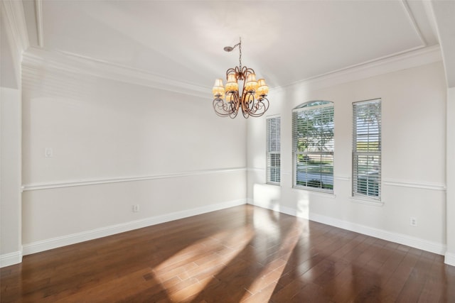 unfurnished room featuring baseboards, crown molding, an inviting chandelier, and wood finished floors