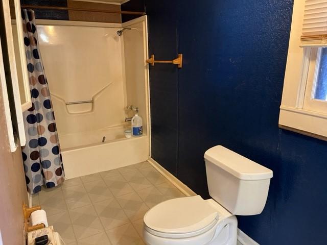 bathroom featuring shower / bath combo and toilet