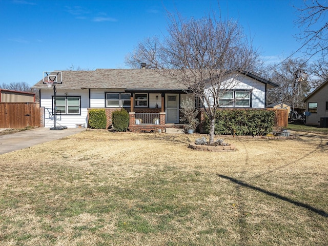 ranch-style home featuring covered porch, brick siding, a front yard, and fence